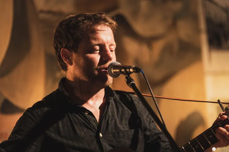 Intense Musical Performance with Vocalist at Microphone in Warm Lighting