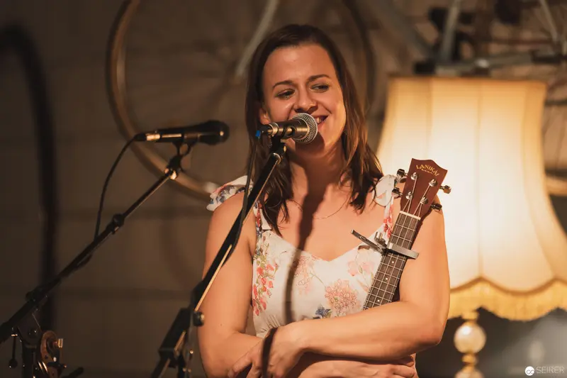 Intimate Acoustic Performance with Guitarist in Warm, Vintage-Lit Setting