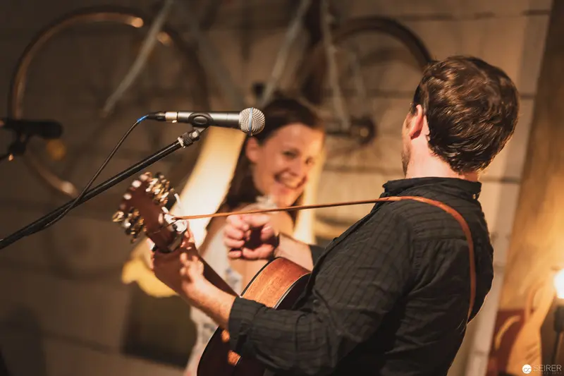 Intimate Musical Duet with Acoustic Guitar and Microphone
