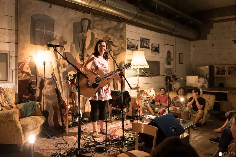 Intimate Acoustic Performance in Rustic Industrial Venue with Attentive Audience