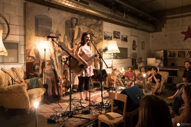 Intimate Acoustic Performance in Rustic Basement Venue with Attentive Audience