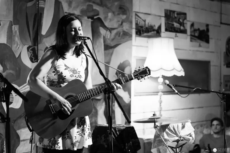 Black and White Performance of Acoustic Guitarist in Intimate Venue Setting