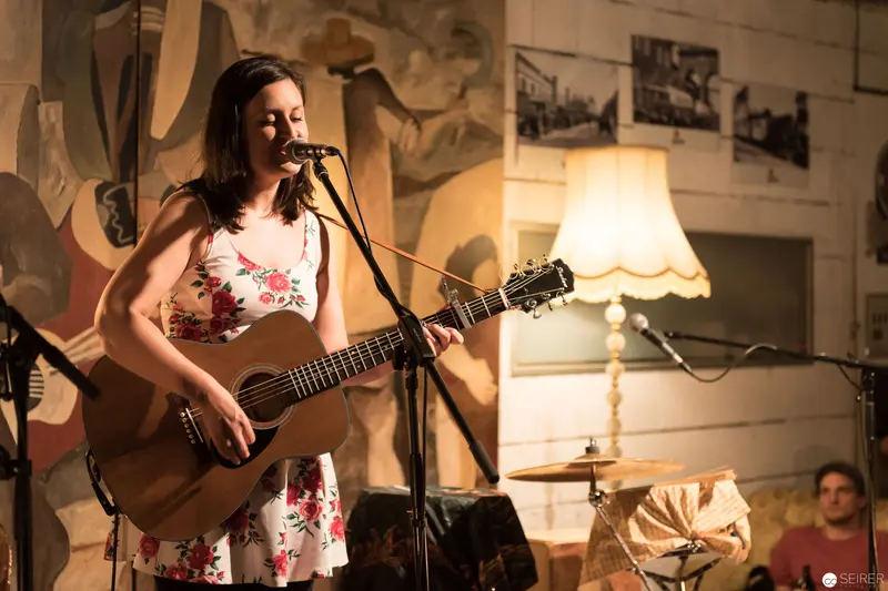 Acoustic Performance in Intimate Venue with Floral Dress and Vintage Lamp