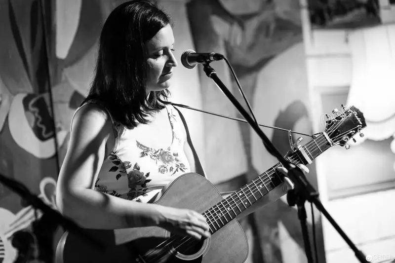 Black and White Performance of Acoustic Guitarist in Intimate Venue Setting