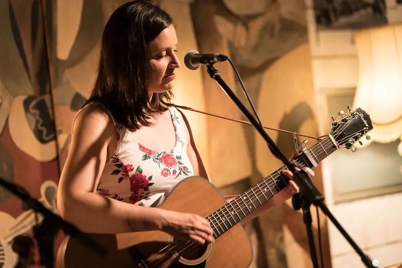 Acoustic Performer in Floral Top Singing at Intimate Venue