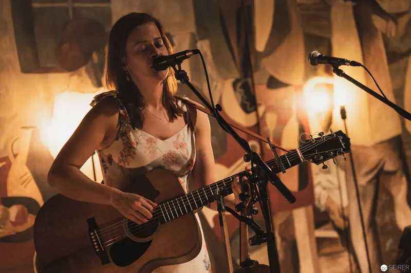 Intimate Acoustic Performance with Warm Ambient Lighting and Hanging Fabrics