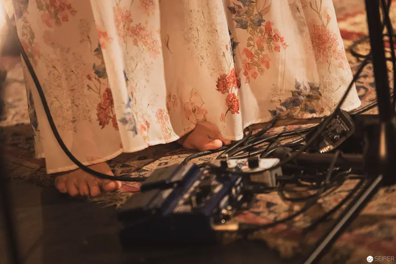 Intimate Moment: Bare Feet and Electronic Equipment in Soft-Lit Setting