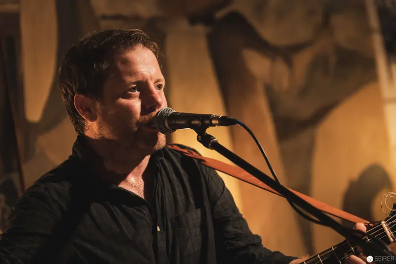 Intimate Musical Performance with Guitarist Singing at Microphone