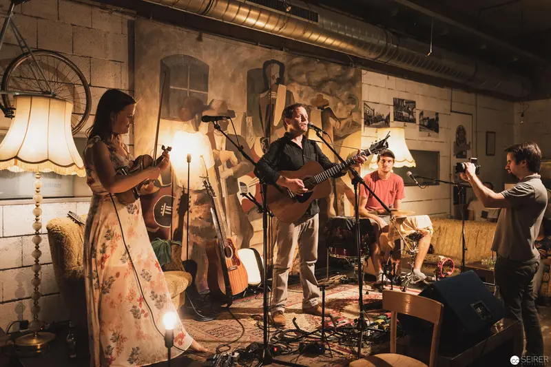 Intimate Acoustic Performance in Rustic Industrial Space with Multiple Musicians