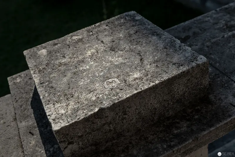 Weathered Stone Block with Textured Surface and Shadowy Edges