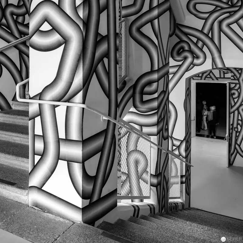 Abstract Geometric Mural with Architectural Interior and Shadowy Doorway