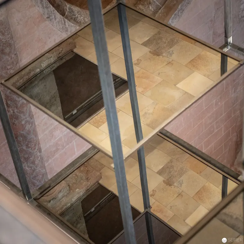 Geometric Reflections: Multilevel Glass and Stone Interior with Tiled Flooring
