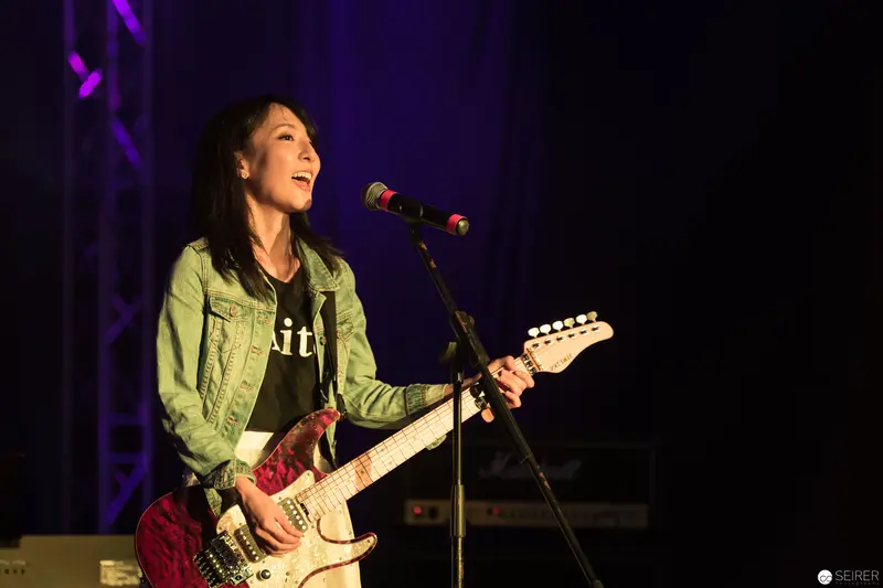Haruka Performing Live at AniNite 2018 with Electric Guitar Under Purple Stage Lights
