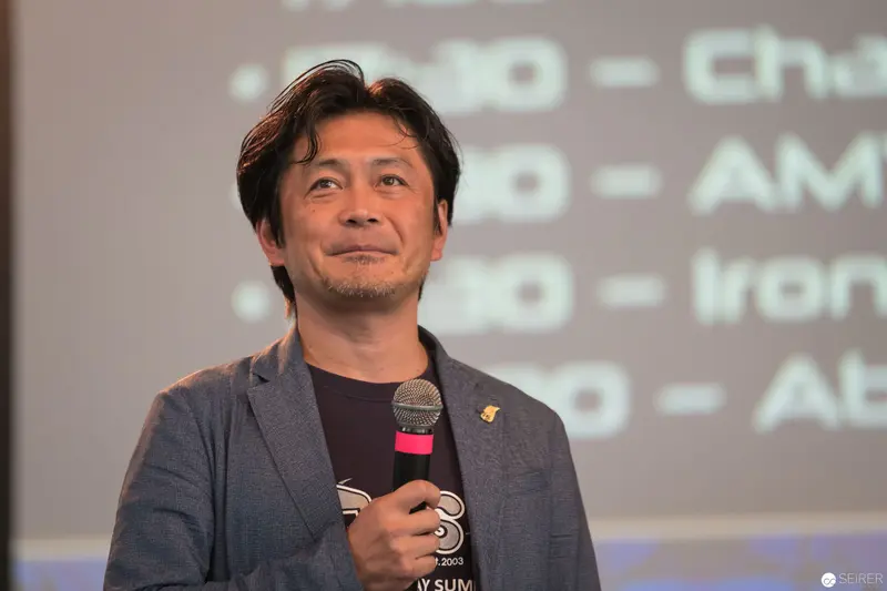 AniNite 2018: Speaker Presenting with Microphone Against Projected Background