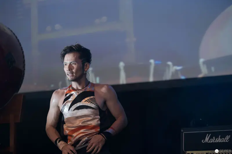 Performer in Stylized Top Under Dramatic Stage Lighting at AniNite 2018