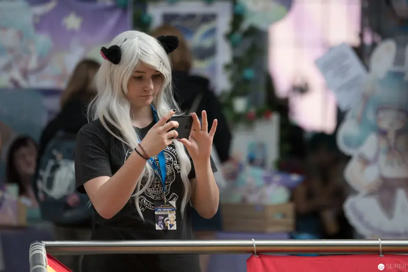 Young Cosplayer Engaged with Smartphone at AniNite 2018 Convention