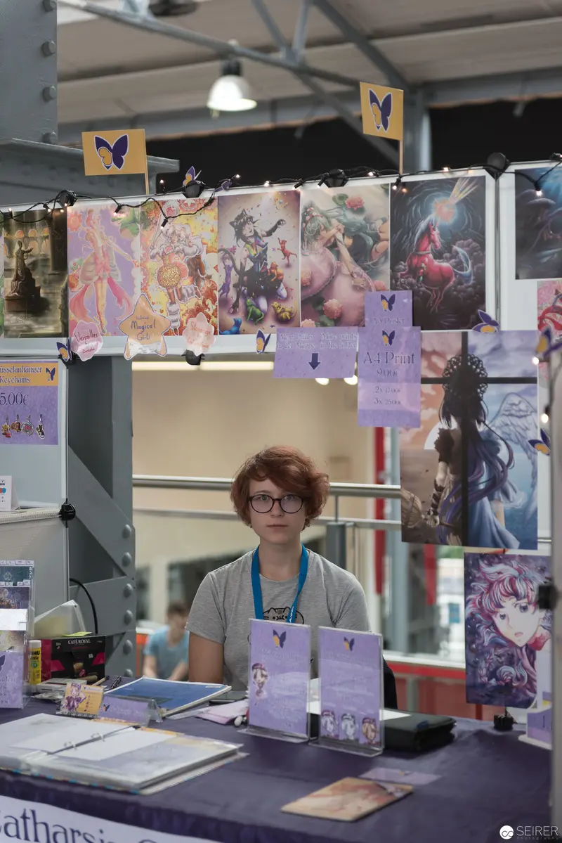 Artist at AniNite 2018 Booth Surrounded by Colorful Illustrative Artwork