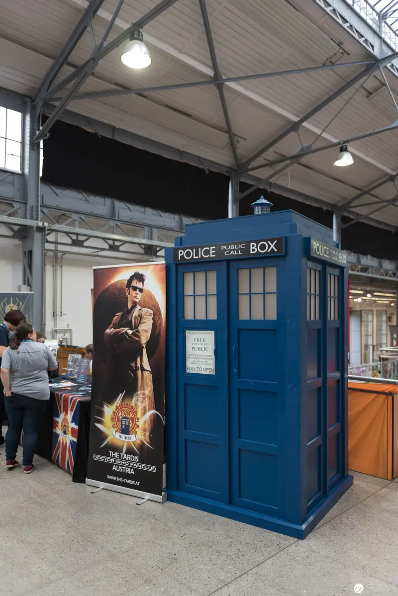 Blue Police Box at Indoor Exhibition Space with Doctor Who Promotional Display