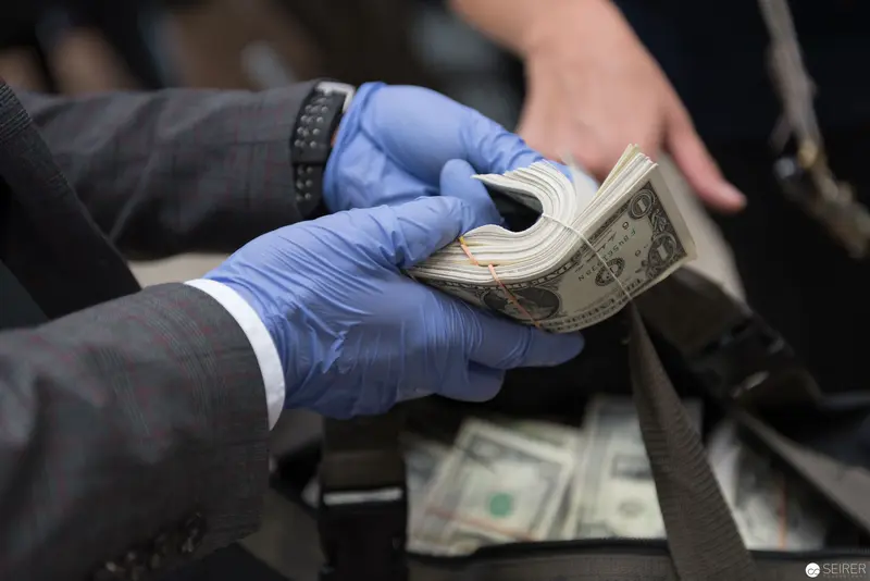 Blue-Gloved Hands Handling Currency in Formal Setting