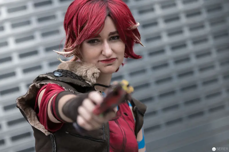 Cosplayer with Vibrant Red Hair Aiming Prop Weapon at AniNite 2018