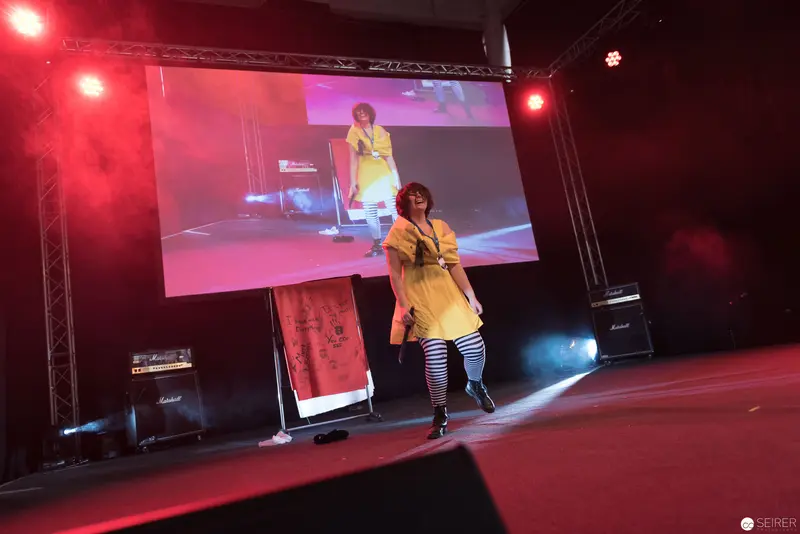 AniNite 2018: Performer in Yellow Dress on Stage with Projection Backdrop