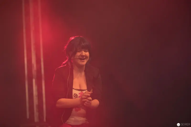 Female Performer Illuminated in Vibrant Red Lighting at AniNite 2018
