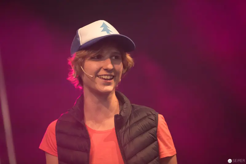 Smiling Performer in Blue Baseball Cap at AniNite 2018 Stage