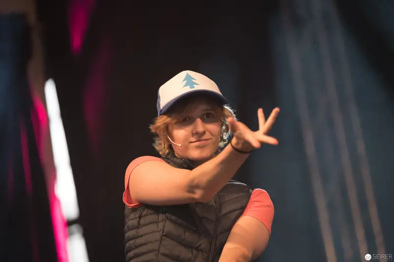 Animated Performer in Pine Tree Cap Gesturing on Stage at AniNite 2018