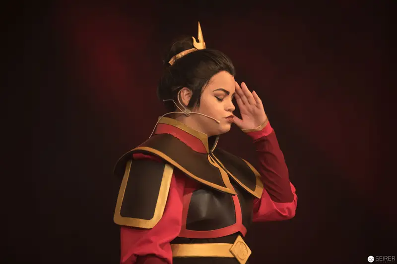 Costumed Performer in Dramatic Pose with Regal Crown and Contemplative Gesture