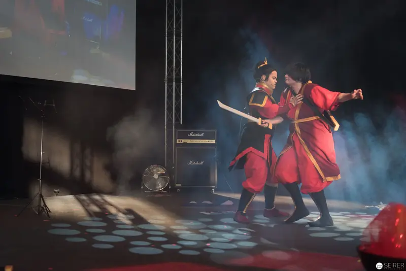 Traditional Asian Performance with Two Dancers in Red Theatrical Combat Pose