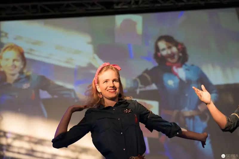 Performer on Stage at AniNite 2018 with Expressive Gesture and Dynamic Backdrop
