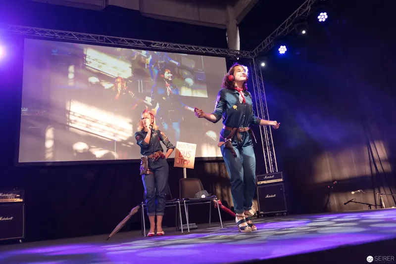 AniNite 2018: Two Performers on Stage with Projected Backdrop