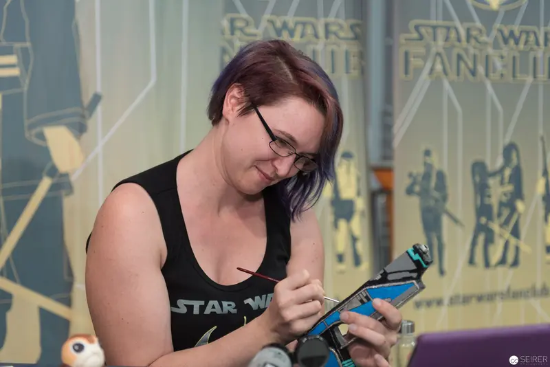 Star Wars Fan Artist Concentrating on Intricate Model Painting at Fan Event