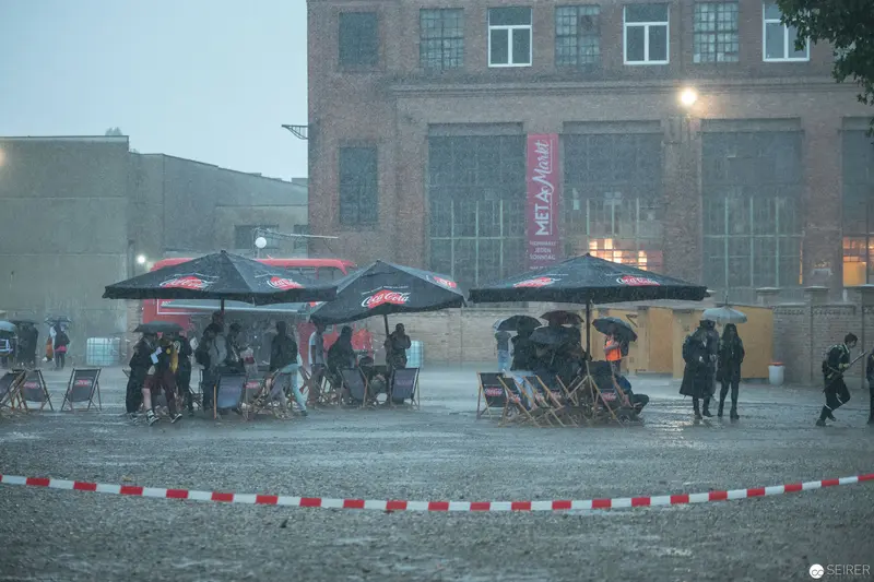 Rainy Outdoor Event with Umbrellas and Sheltered Seating Areas