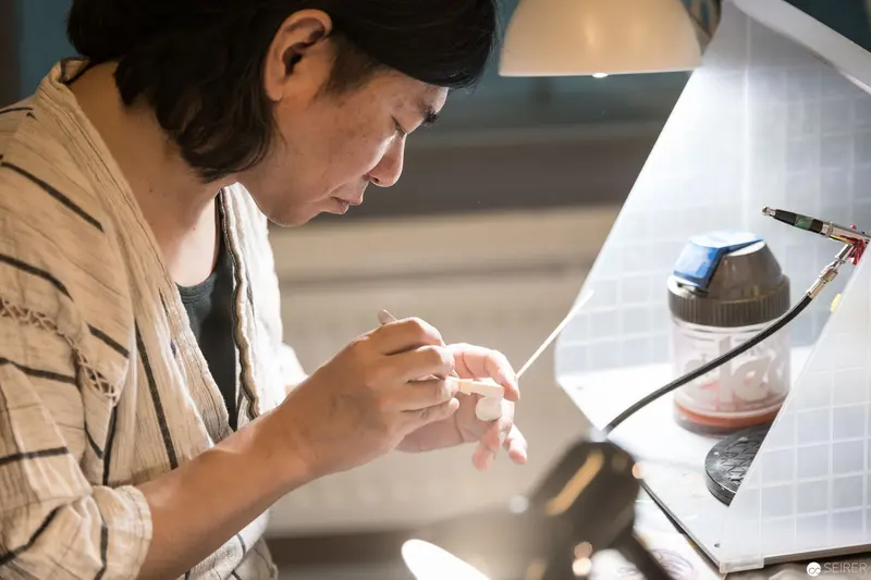 Artisan Concentrating Intently on Delicate Craftsmanship at Workbench