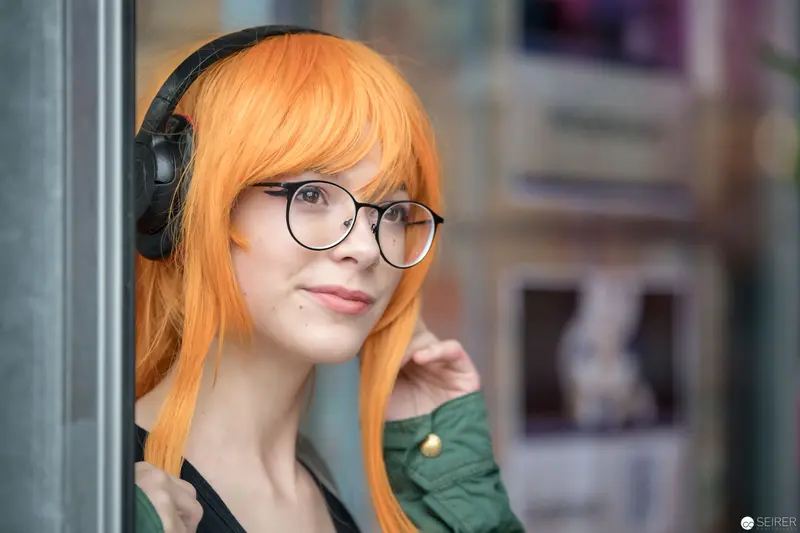 Young Woman with Orange Hair and Headphones in Contemplative Pose