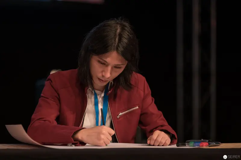 Focused Participant Writing Intently During AniNite 2018 Event