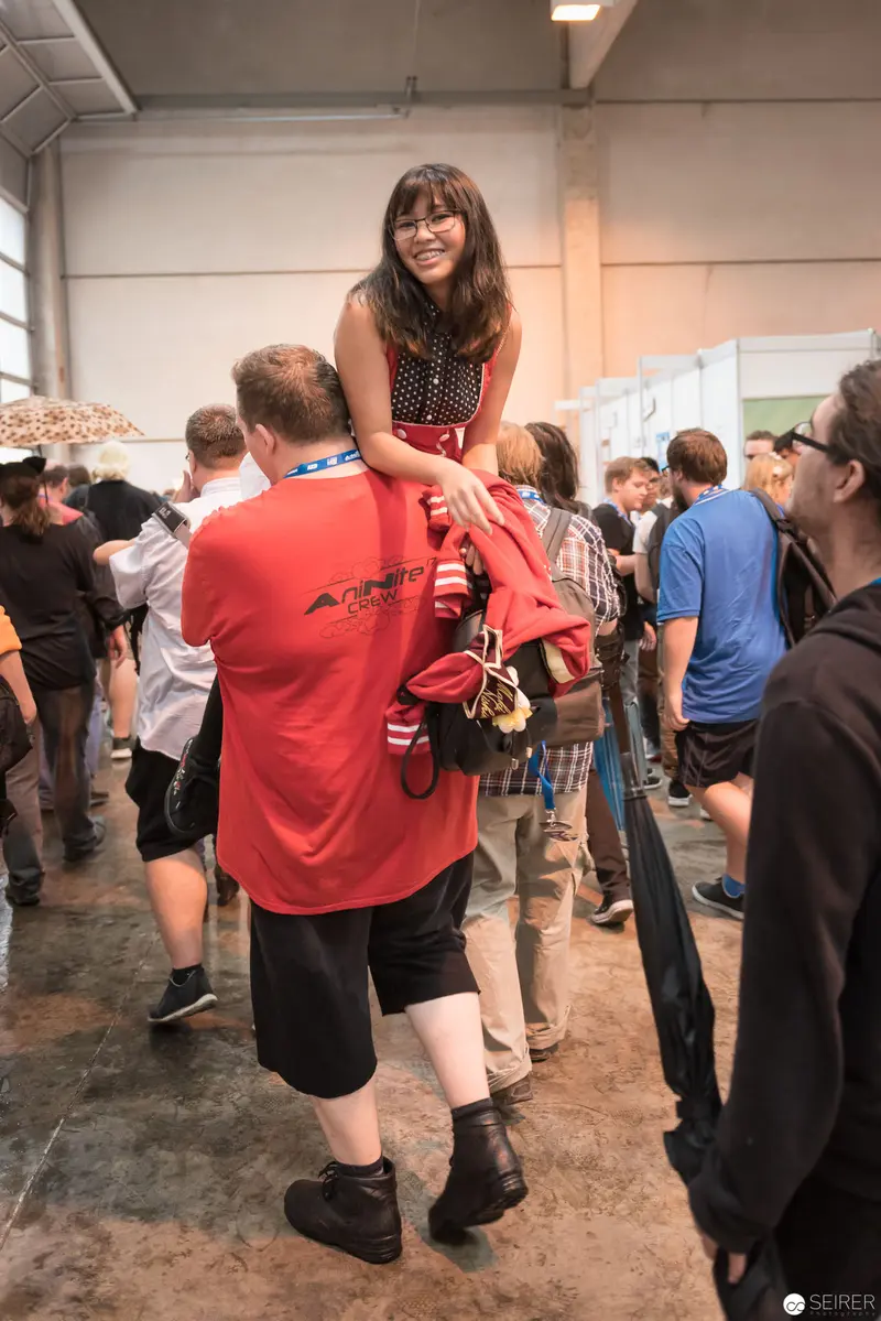 Crowd Scene at AniNite 2018: Woman Seated on Shoulders Amid Bustling Event Space
