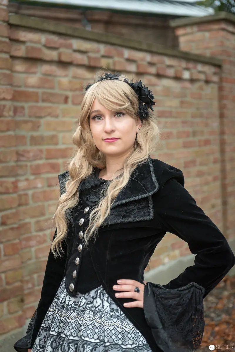 Gothic-Inspired Fashion Portrait against Brick Wall Backdrop