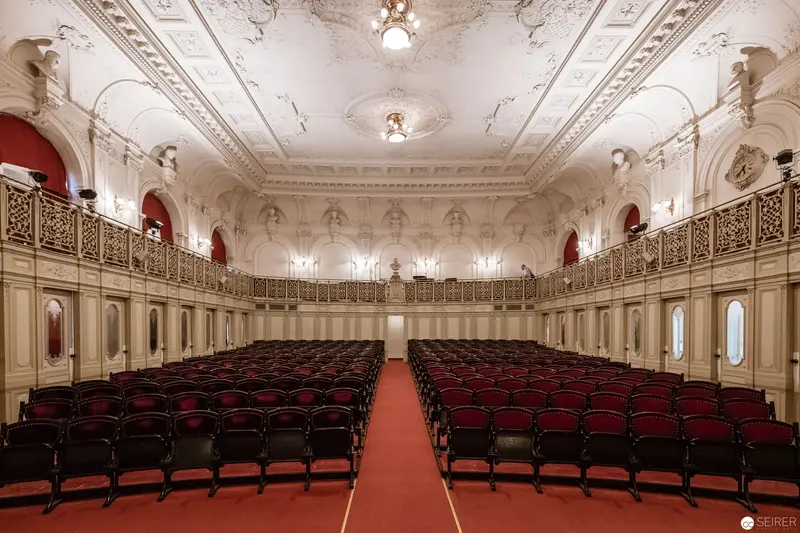 Ornate Classical Concert Hall with Red Seating and Intricate Baroque Ceiling