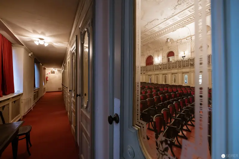 Empty Theater Hallway with Red Carpet and Ornate Performance Space