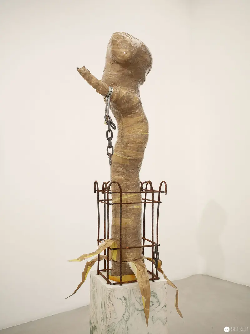 Bound Figure Suspended in Rust-Colored Cage Sculpture