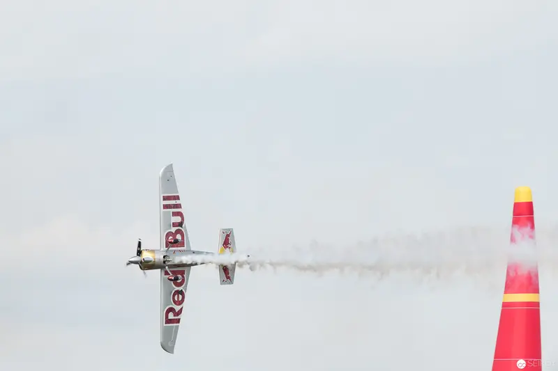 Red Bull Air Race Stunt Plane Cutting Through Pale Sky with Marker Pylon