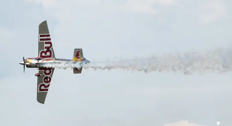 Red Bull Air Race Stunt Plane Executing Precision Aerobatic Maneuver Against Pale Sky