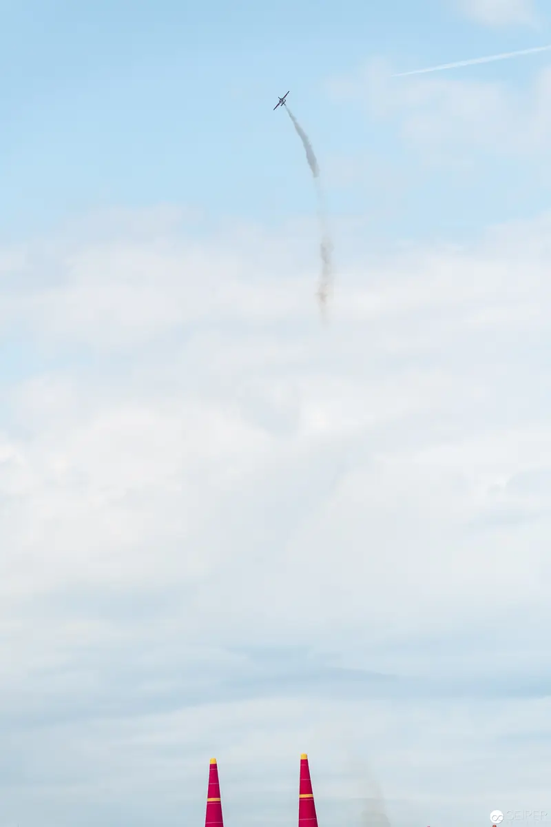 Red Bull Air Race: Aerial Precision Against Soft Blue Sky and Crimson Pylons