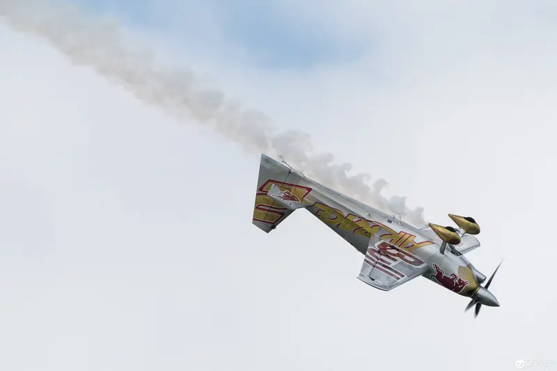 Red Bull Air Race Stunt Plane Executing Dramatic Aerial Maneuver Against Pale Sky
