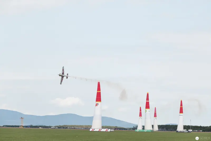 Red Bull Air Race Aircraft Navigating White Pylons Against Pastoral Landscape