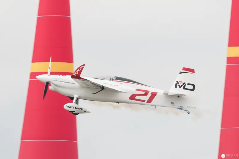Red Bull Air Race Precision Racer No. 21 in Flight Between Crimson Pylons