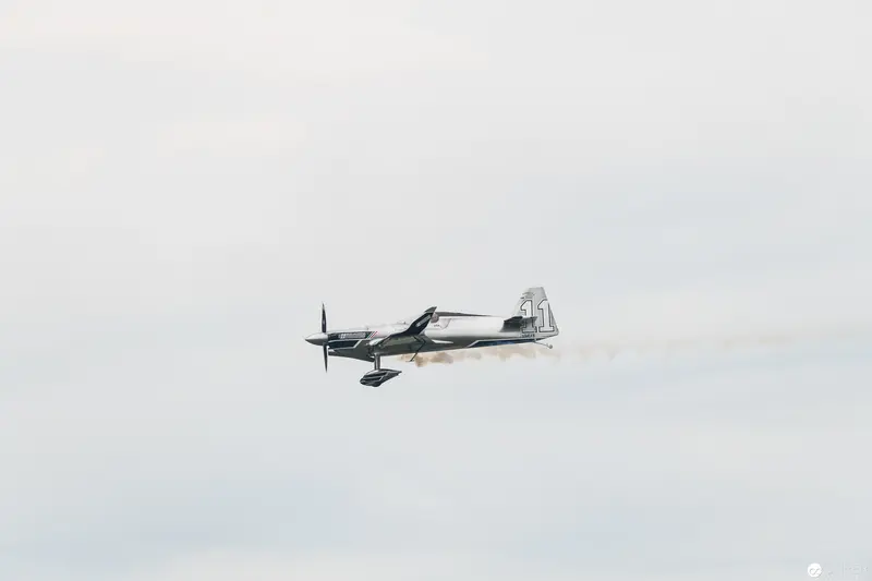 Red Bull Air Race Stunt Plane Executing Precise Aerial Maneuver Against Pale Sky