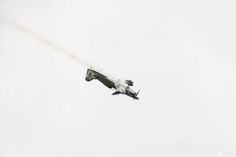 Red Bull Air Race Stunt Plane Executing Dramatic Mid-Air Maneuver Against Pale Sky